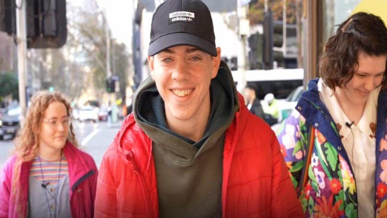 Three disabled young people walking together and smiling.