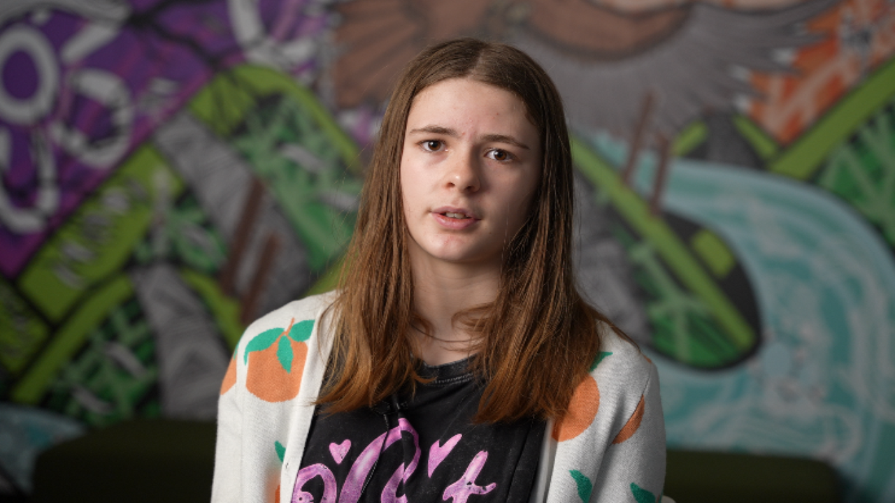 Thali, a disabled young person, looking directly at the camera.